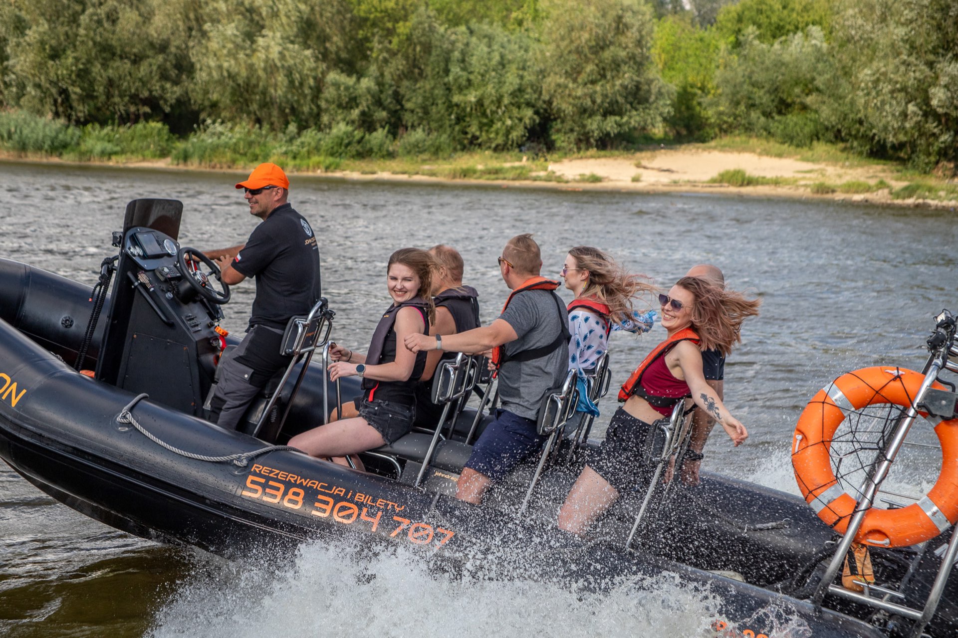 Motorówka John Dragon z widoczną grupą pasażerów w kamizelkach ratunkowych podczas rejsu po Wiśle